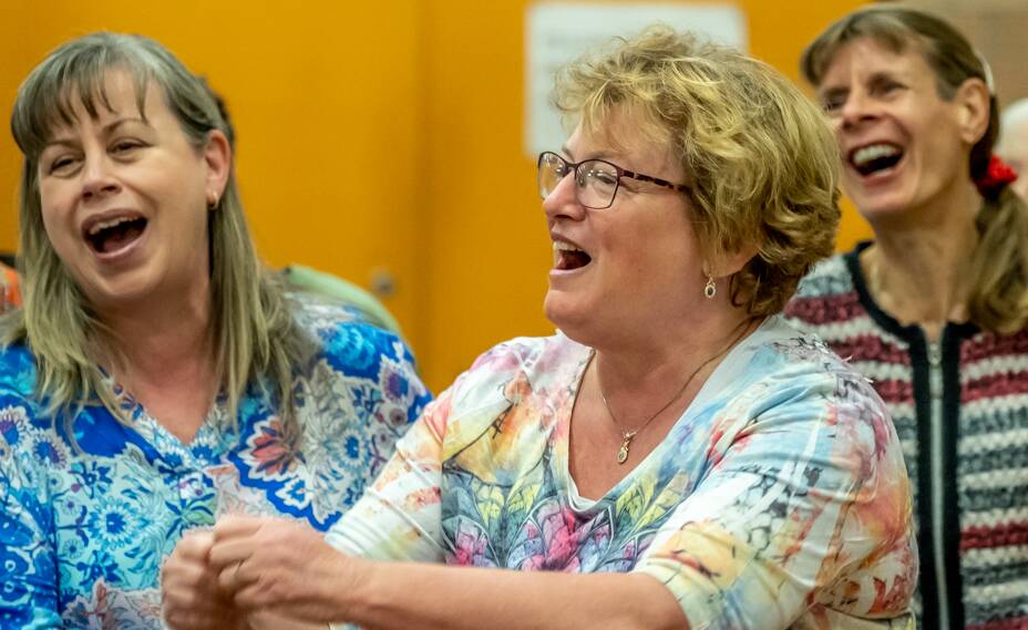 Shoalhaven singers Wendy Bilbey and Susan Dowsett raise their voices during a community singing event with Food of Love  musical director Joy Sharpe. Photo: Patrick McSwiney.