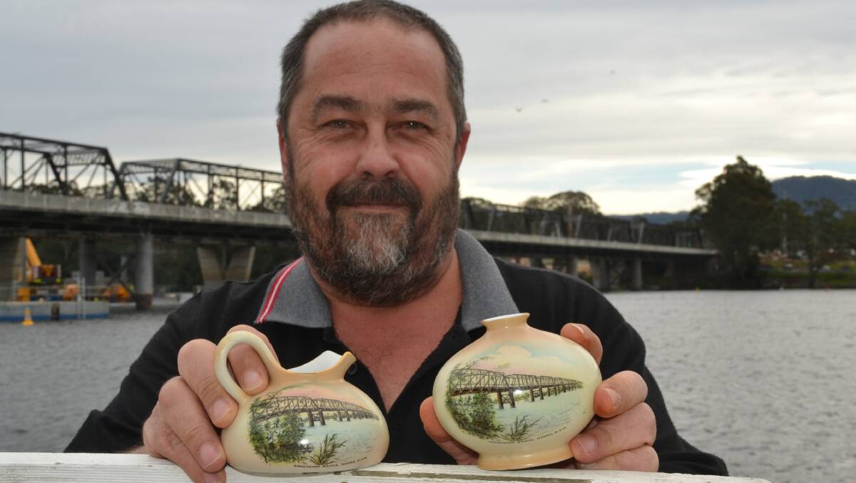 Shoalhaven collector Adam Manly with examples of early "souvenir ware" featuring paintings of the iconic original Nowra Bridge. Photo by Robert Crawford.