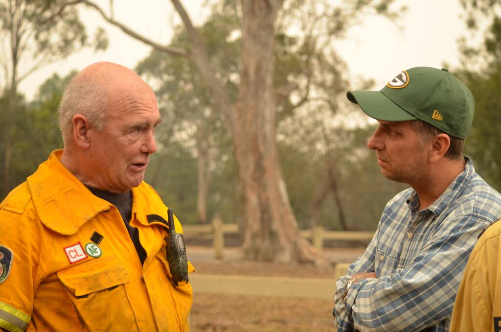 RFS volunteer Wayne Curle speaks with Bega MP Andrew Constance on New Year's Day at Mogo.