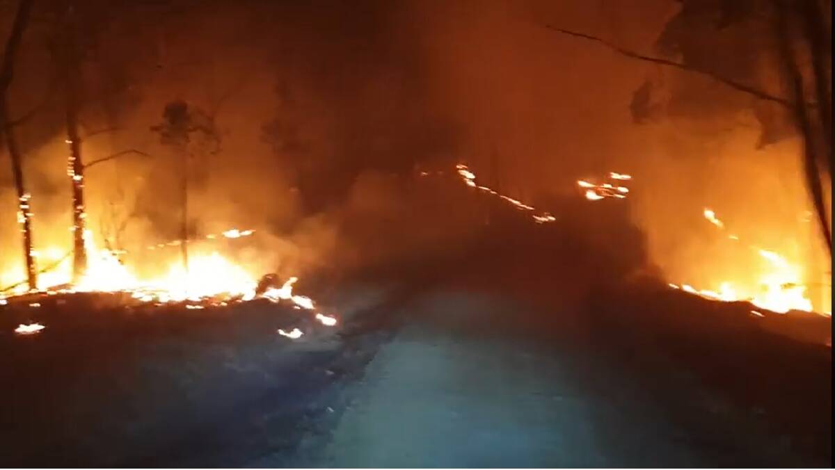 A still from a video captured by RFS Basin View, who had a busy night with both trucks involved with property protection at the Currowan fire near Shallow Crossing. Picture: NSW Rural Fire Service Basin View Brigade.