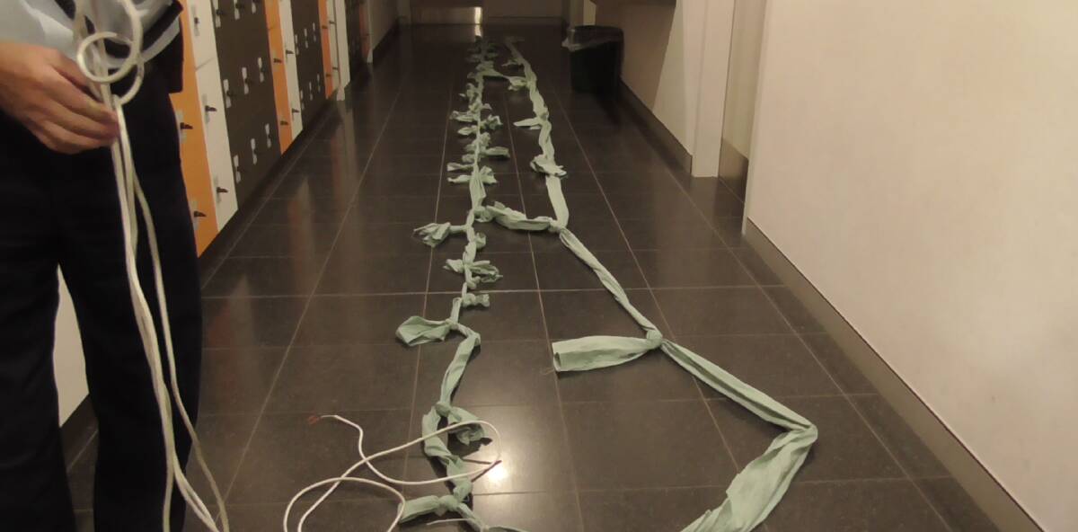 SHEETS: A Corrective Services officer with the makeshift rope discovered when a jail escape bid was discovered at the South Nowra jail.