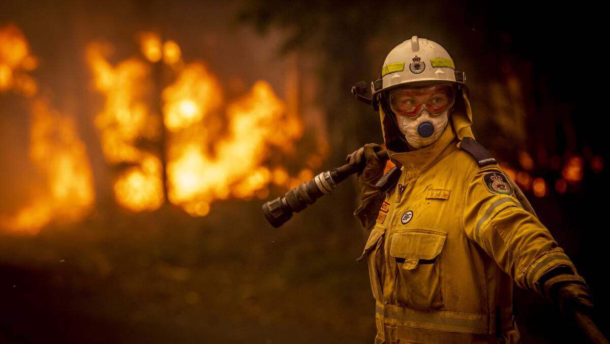 A NSW Rural Fire Service volunteer works to battle a bushfire on Murramarrang Road in Bawley Point on Thursday afternoon. Picture: Sitthixay Ditthavong