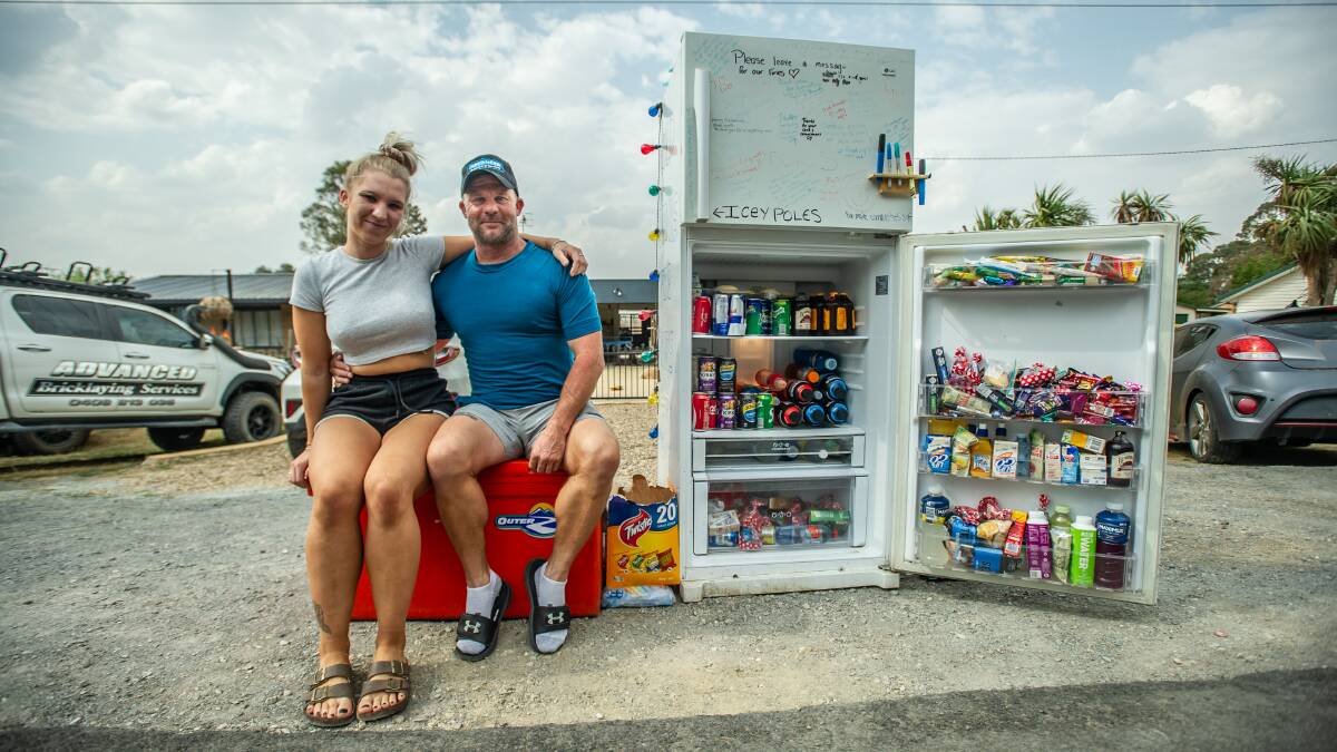 Bungendore's Scott Hooper (and daughter Dannielle) have set up a fridge in front of their home stocked with frozen treats, cold drinks and snacks for passing firefighters on their way to and from the Coast. Picture: Karleen Minney