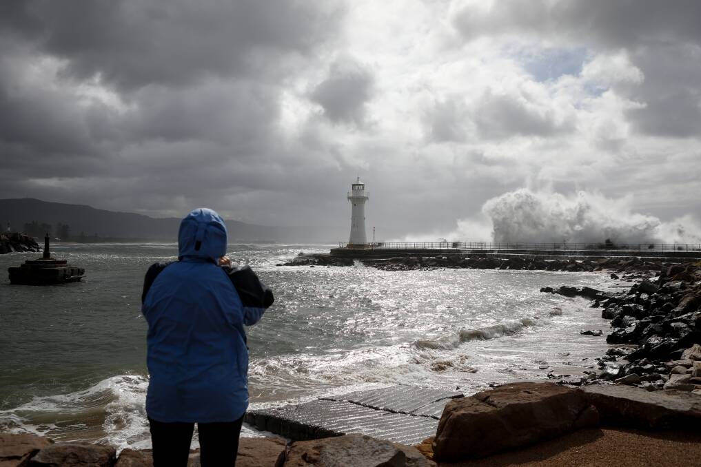 Hazardous surf and gale force winds hit the Illawarra coast on Monday. Cynthia Shuttleworth watches the fierce waves crash over Wollongong Harbour's breakwall. Picture: Adam McLean