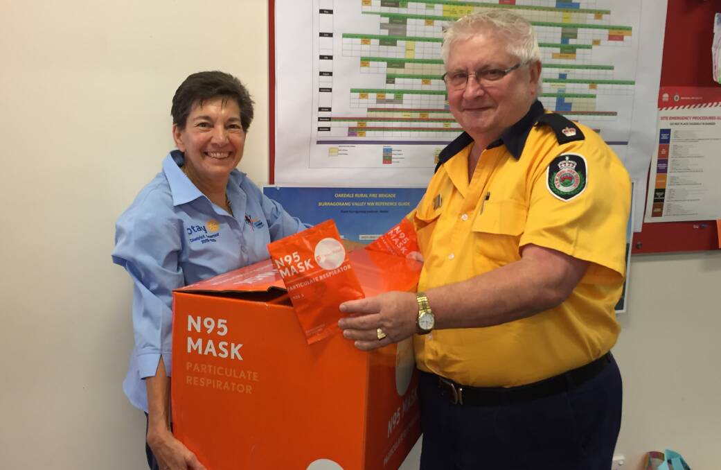 Rotary District Governor Dianne North hands masks over to Picton RFS Inspector David Stimson.