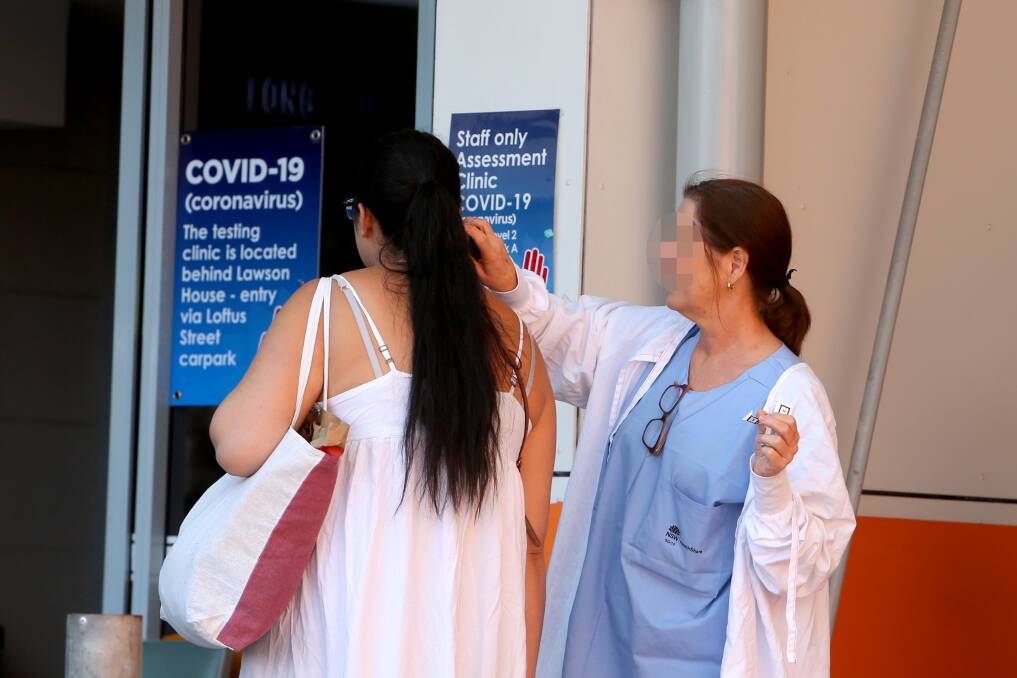Staff carry out temperature checks on visitors and staff at Wollongong Hospital on Monday morning. Picture: Sylvia Liber