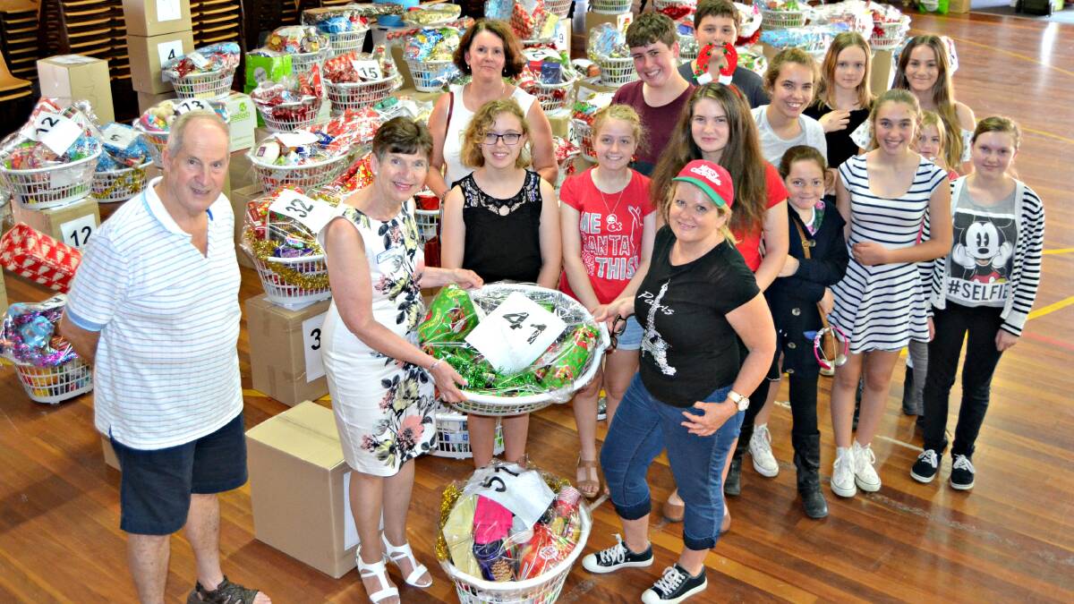 HAMPERS GALORE: St John the Evangelist Catholic High School students and teacher Kathy Woodall present Wendy and Paul Reid from St Vincent de Paul with 48 Christmas hampers. 