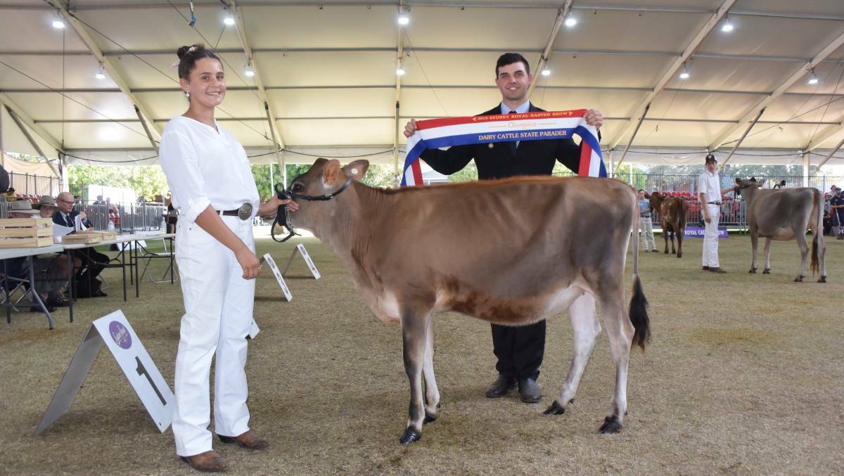 GOING PLACES: NSW champion dairy parader at the Sydney Royal Show, Elly Simms from Nowra, presented with the champion ribbon by Manning Valley judge Cameron Yarnold. Photo: The Land. 

