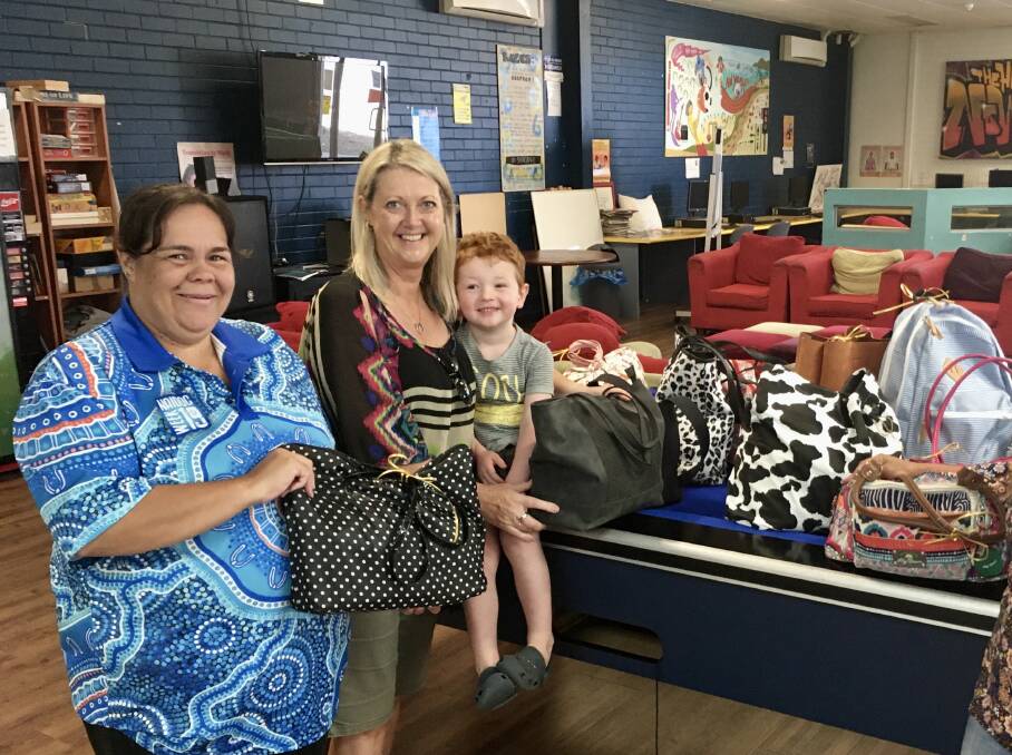 BAG OF HAPPINESS: Share the Dignity volunteer Jeanine Leyshon and her young grandson, Henry drop off some beautiful bags filled with goodies for Nowra Youth Services manager Janet Atkins to distribute to women in need. Photo supplied. 
