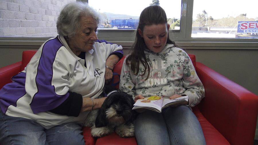 LOVE OF READING: Catherine, Daisy and Victoria engrossed in a book. Photo: supplied. 