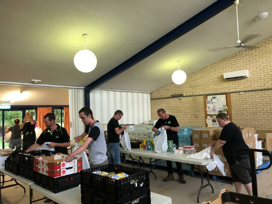 Volunteers are kept busy unpacking food and stocking hampers.
