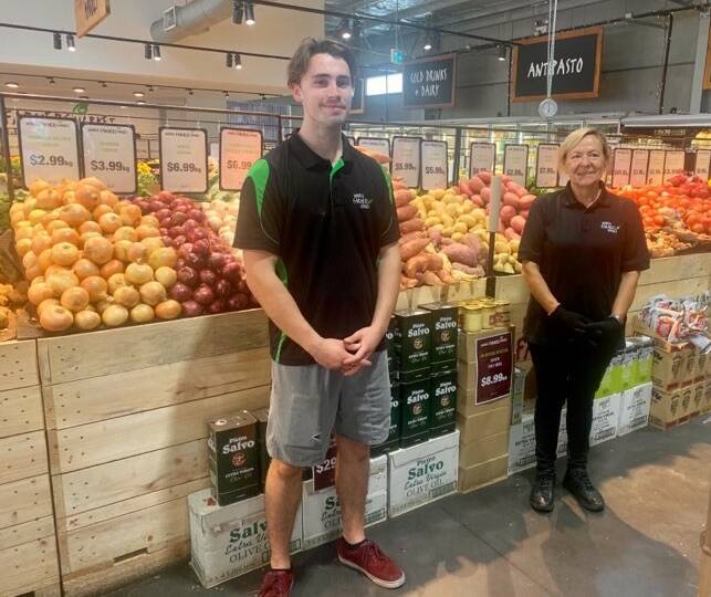 SHOP SMART: Employees James Waters and Zofia Dadelewska at Nowra Farmers Market on Tuesday, March 24. There has been a surge in demand for some products.