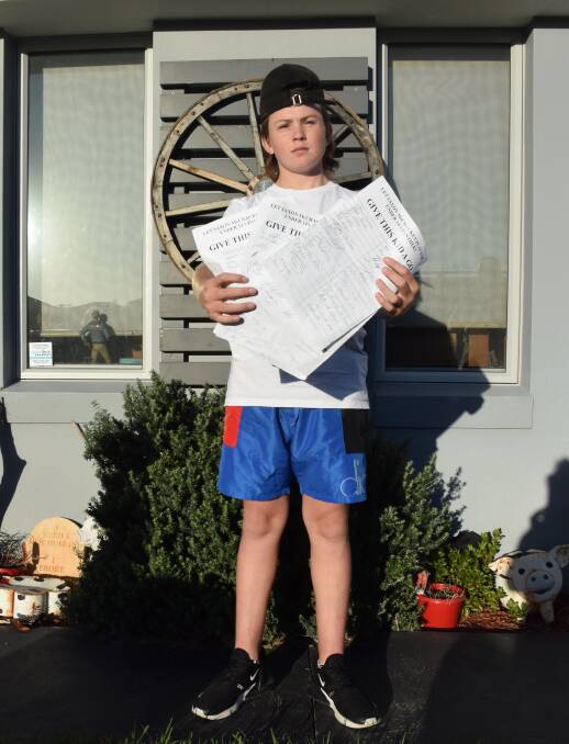 Saxon McCracken with signed copies of a petition calling for him to be allowed to play for Sussex Inlet Rugby League Football Club.