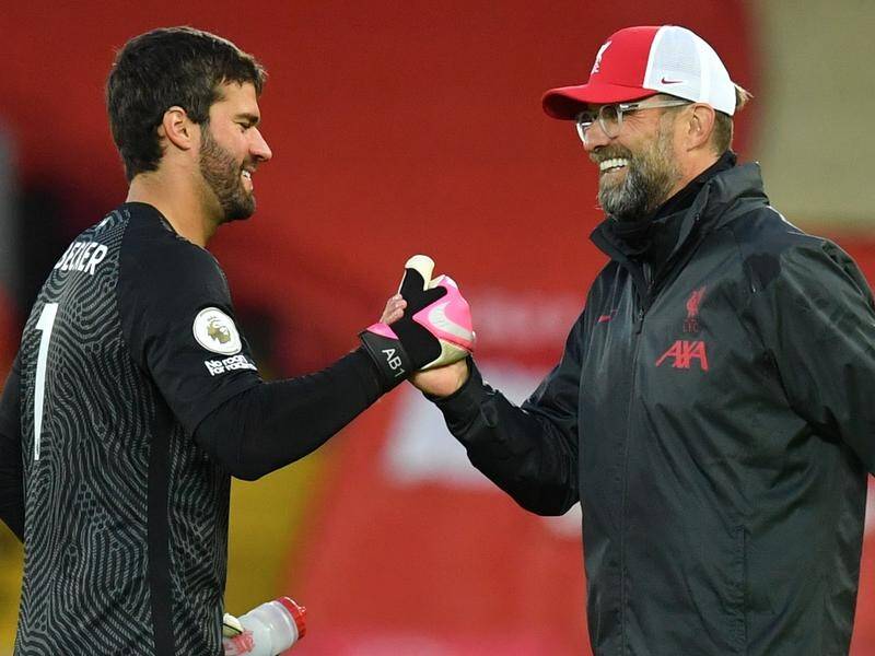Liverpool goalkeeper Alisson (l) could be out of action for some time says coach Juergen Klopp (r).