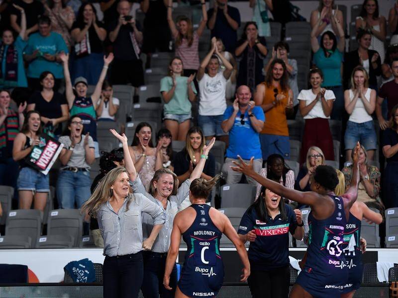 Melbourne Vixens players and staff celebrate victory in the Super netball grand final.