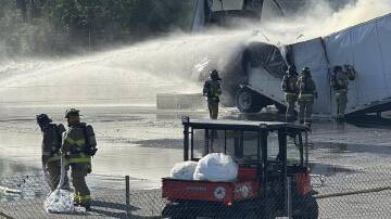 Firefighters tried to extinguish a blaze that began on a trailer carrying lithium batteries. (AP PHOTO)