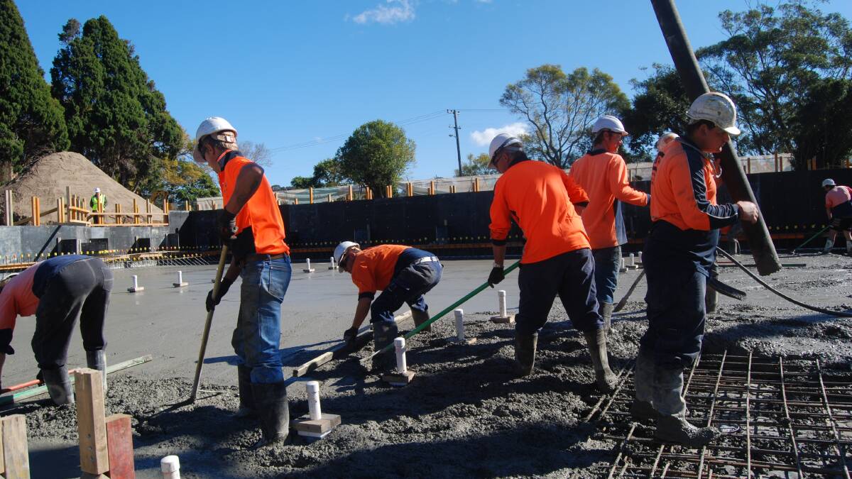 SMOOTH OPERATORS: Workers smooth out the concrete in the shallow end of the new Nowra pool.