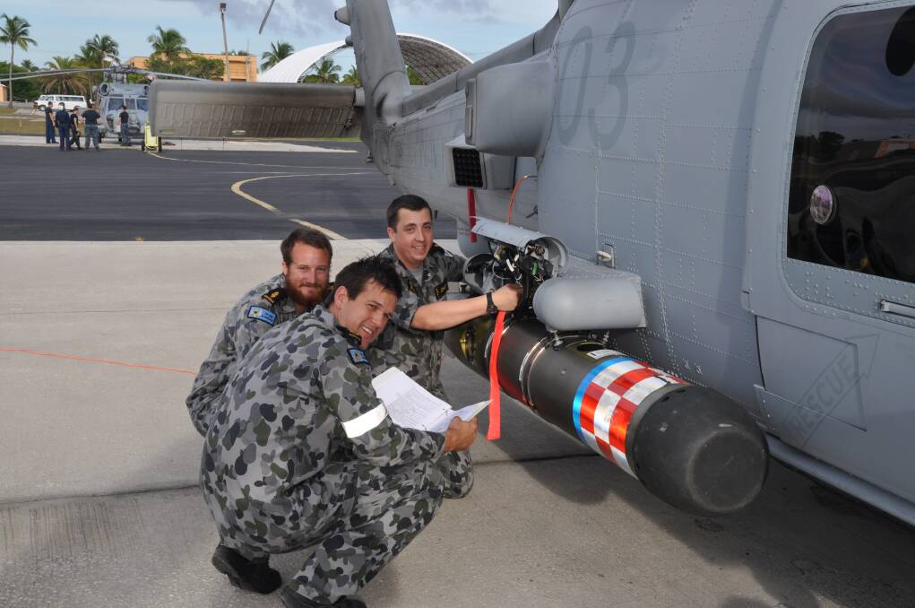 PAYLOAD: Aircraft maintainers (from left) Petty Officer Matthew Pollman, Able Seaman Brent Campbell and Able Seaman Geoffrey Johnson load the Mk 54 torpedo onto a MH-60R Romeo in Florida.