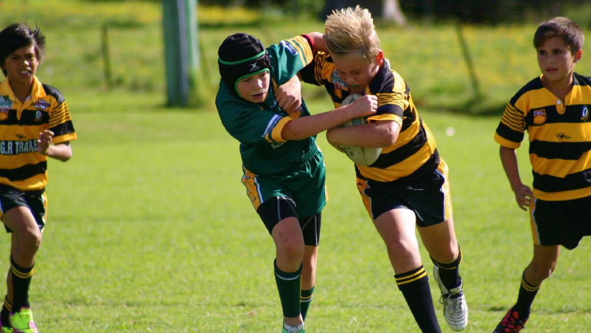 IT’S MINE: Nowra Warriors under 11’s player Jonah Longbottom wrestles with the defence eager to gain any ground during the round four match last weekend. 