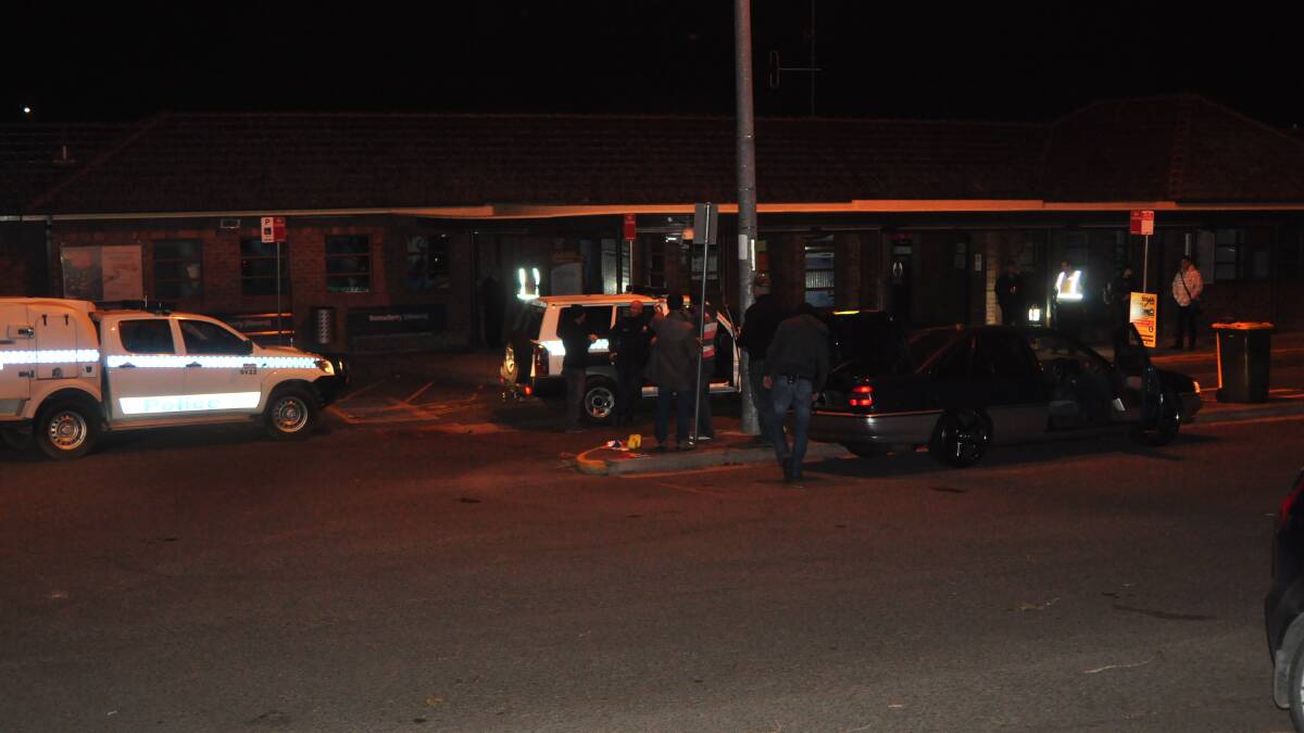 Officers from the State Crime Command gather evidence from a vehicle at Bomaderry railway Station on Tuesday night. 
