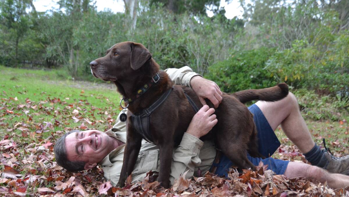 Jeff Ewers from Woollamia with Charlie the Labrador after an overnight ordeal trapped on a cliff.