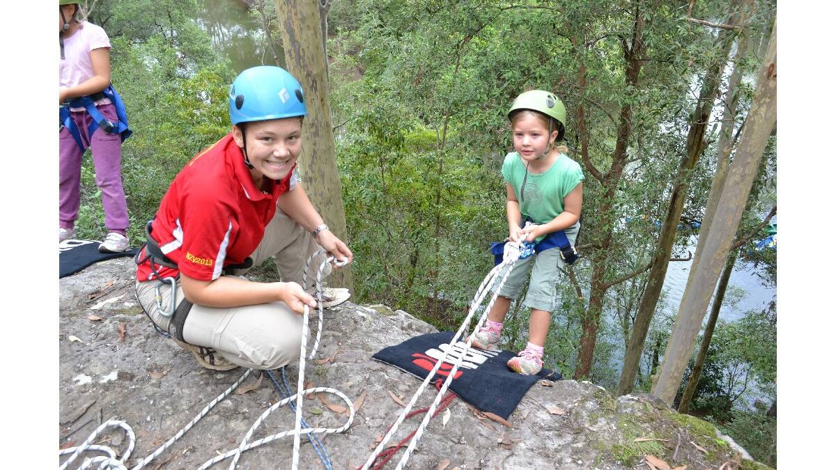 Lucy Summerville from Kiama Guides prepares to abseil down the side of the cliff at the Combined Camp of Guides and Scouts at Bangalee Scout Camp on Saturday.