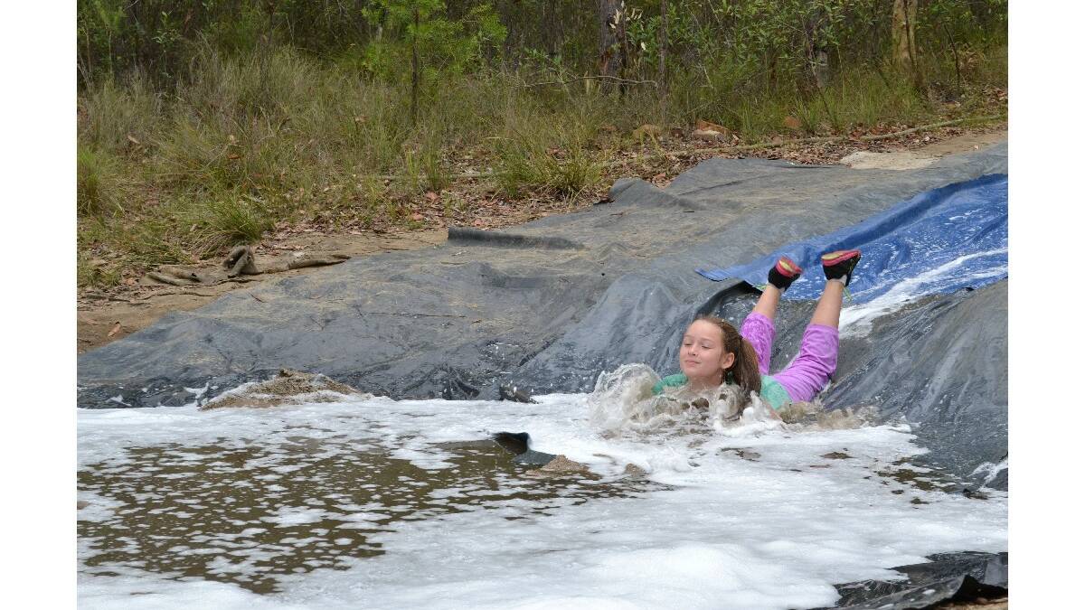 Kara Murphy from Bungendore makes a splash on the commando course at the Combined Camp of Guides and Scouts at Bangalee Scout Camp on Saturday.