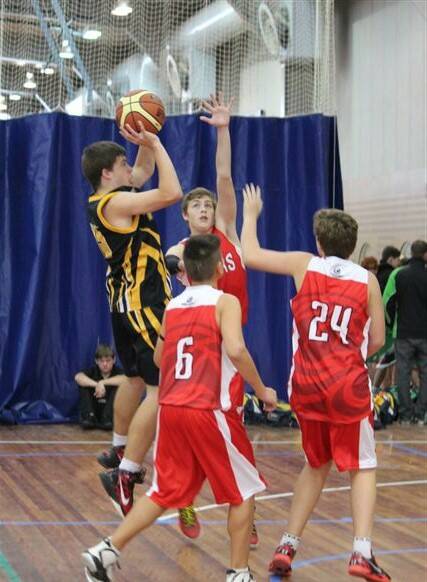HIGH BALL: Bomaderry Tigers’ Jayden Glendenning goes up for a basket against Illawarra in round one of the Waratah Southern Junior League under 16 boys competition
