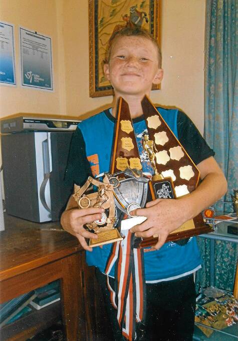 TOO MANY TO HOLD: Kalvin Bown proudly shows off the Peter Cotter Trophy he was presented with at the St Georges Basin Little Athletics Club presentation.