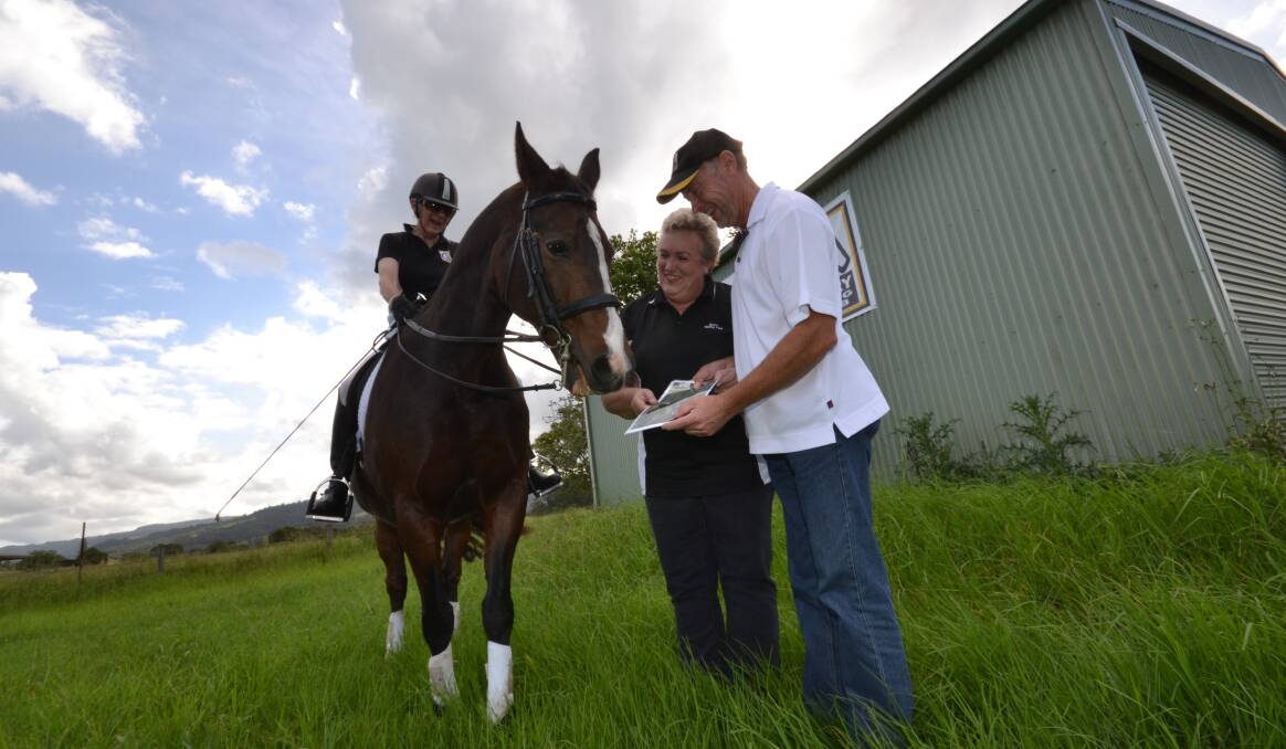 NEW HORIZON: Grahame and Judy Sweeney from the Berry Riding Club look at plans for the club’s potential new site with Julee Jones on her horse.