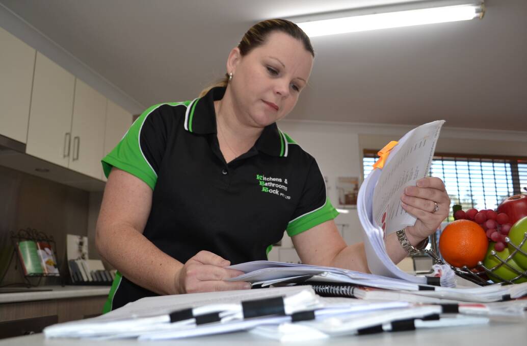 Cheryl Stanton of Kitchens and Bathrooms Rock at Bomaderry looks through the paper trail records of how the company was defrauded of close to $100,000.