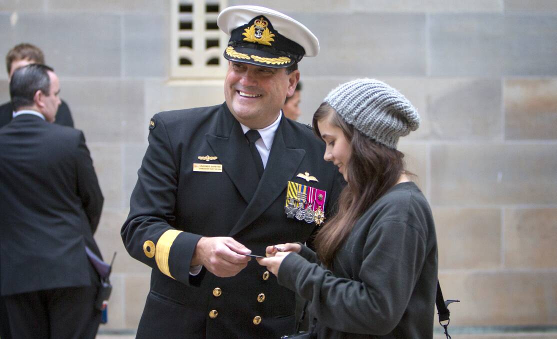 
Commander Fleet Air Arm, Commodore Vince Di Pietro, presents a navy coin and pin to Eryn Shipp, Leading Seaman Aircrewman Noel Shipp's granddaughter, at the Australian War Memorial. Photo: PAUL BERRY 
