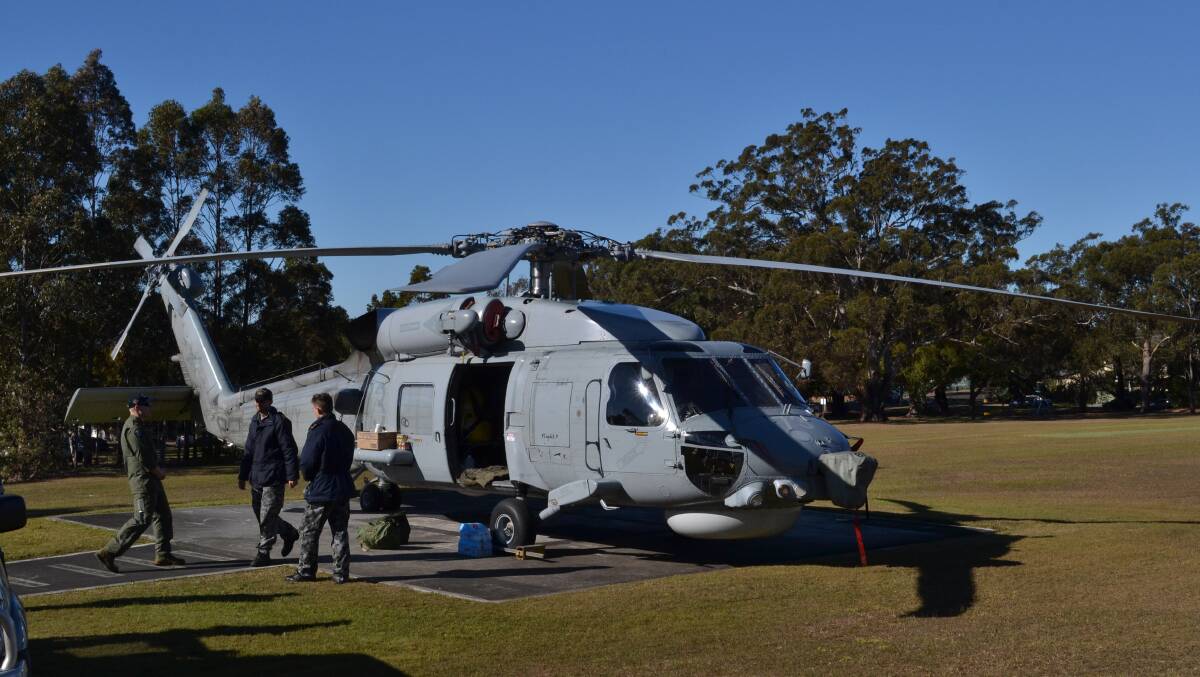 Maintenance crews from HMAS Albatross work  to fix an engine problem with a Seahawk helicopter from 816 Squadron, which is based aboard HMAS Newcastle, on the helipad of Shoalhaven Hospital.