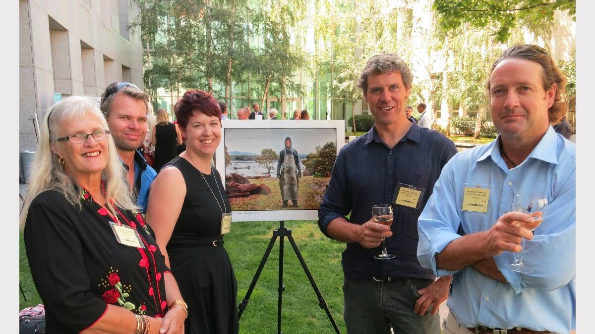EDEN: Local oyster growers at the exhibition launch of ‘Faces of Australia's Oyster Coast’ in Canberra. (From left) Anne, Andrew and Stacey Loftus from Wonboyn, Greg Carton from Pambula and Brett Weingarth of Merimbula pose with Heide Smith’s photograph of fellow oyster farmer Paul Emmanuel of Wapengo