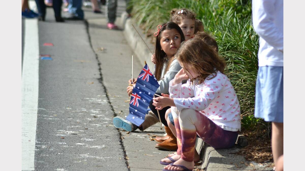 Children sit curb side, waiting for the 2014 Berry Anzac Day march to begin.