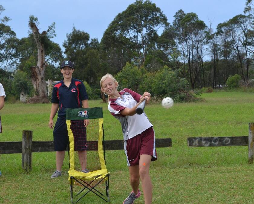 Vincentia High School student Emily Lang belts the ball during baseball at the Girls Get Active Schools Day in Bomaderry.