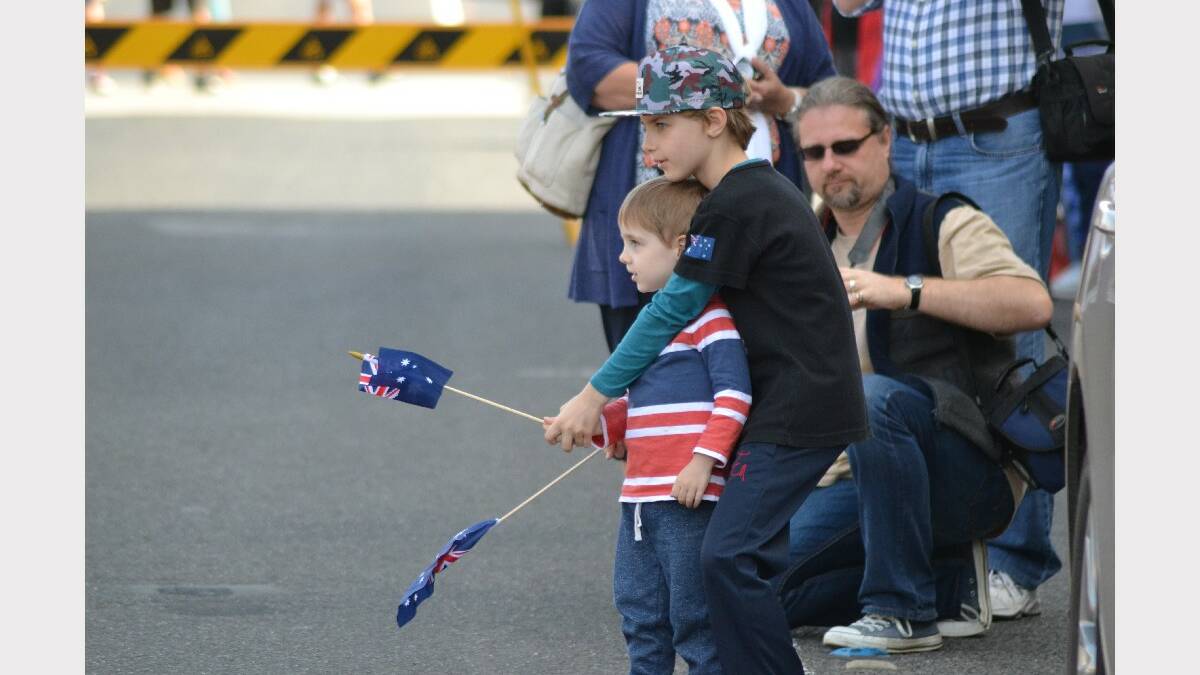 Young boys wave their Australian flags as they wait for the 2014 Berry Anzac Day march to begin.