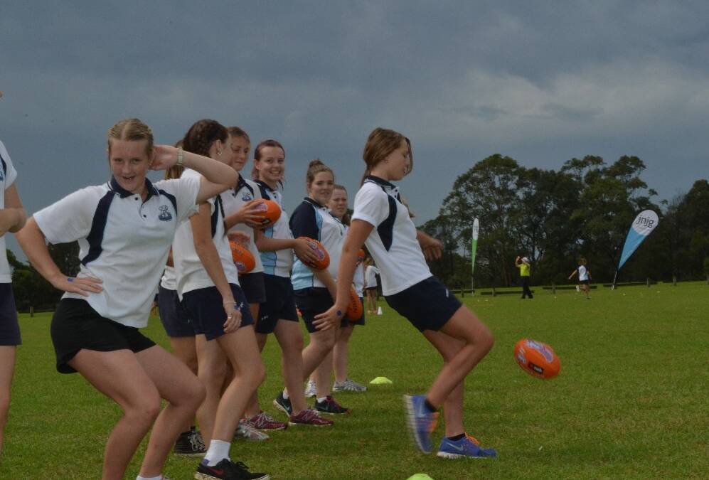 Nowra High School Dakotah Mannering hams it up for the camera while Bianca McIver sends the ball over the posts during the Girls Get Active Schools Day.