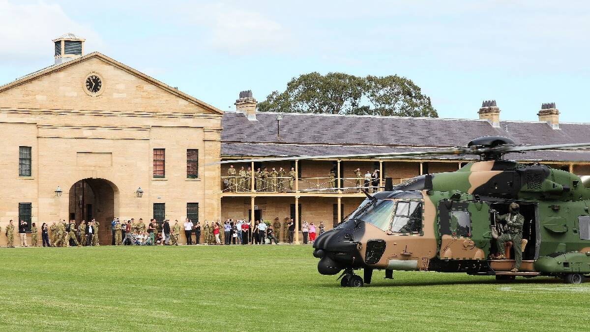 Members of Defence watch on as the Duke and Duchess of Cambridge are being transported by a Navy MRH90 helicopter out of Victoria Barracks, Sydney.
