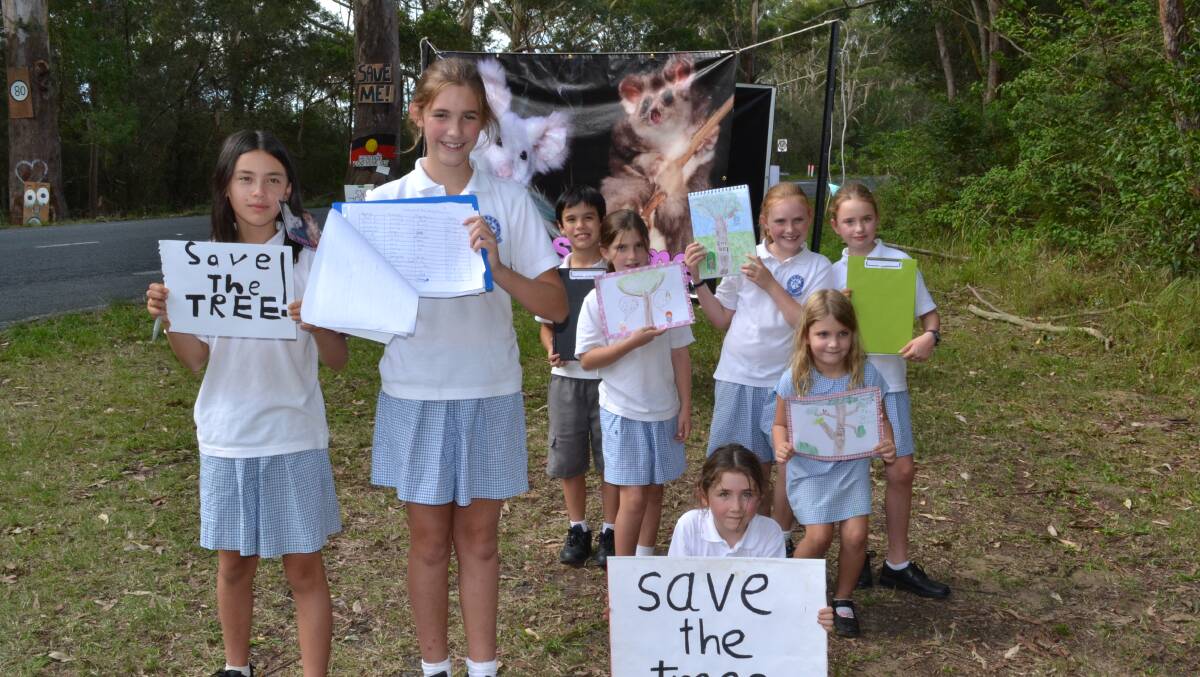 LEAVE THEM ALONE: Berry Public School students staged their own mini protest over the clearing of vegetation on Gerroa Road on Wednesday afternoon as well as displaying the collected signatures on their petition; Lucy Leung, Milly Thomson, Jasper Leung, Bronte Thomson, Audrey Terry, Gemma Thomson, Aisha May and Keira Shannon.