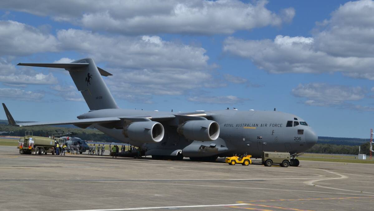 MASSIVE MACHINE: One of the RAAF Boeing C-17 Globemaster III transporters at HMAS Albatross, which are being used to transport three Seahawk helicopters and 83 personnel from 816 Squadron to Western Australia for anti-submarine exercises. Right: HMAS Albatross personnel from 816 Squadron load one of the three Seahawk helicopters onboard Boeing C-17 Globemaster III transporter.