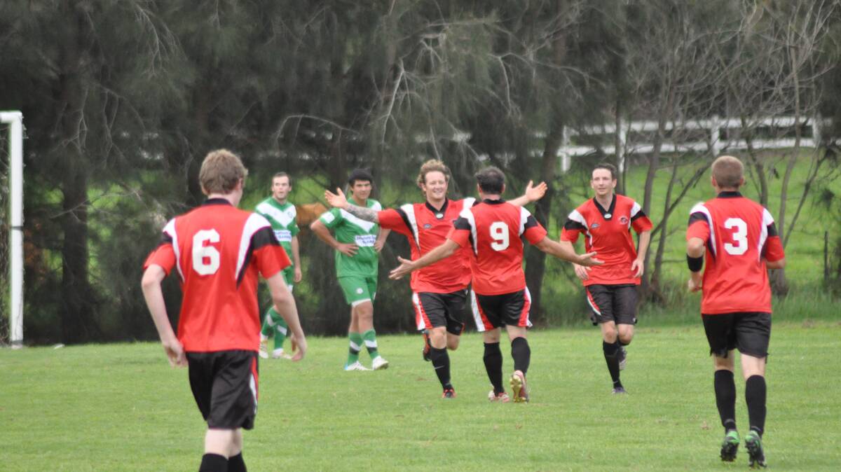 HAT-TRICK HERO: Shoalhaven United striker Shane Button celebrates with his team mates after netting his third goal in their 4-1 win over Huskisson. Photo: PATRICK FAHY