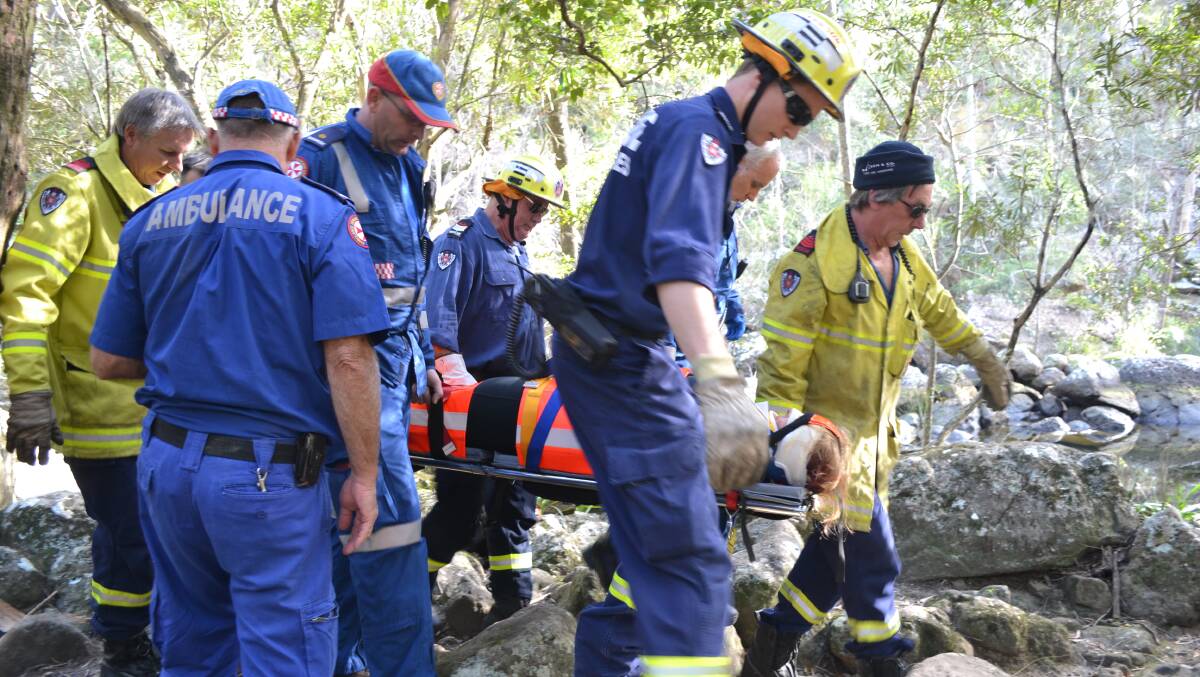 LONG HAUL: NSW Ambulance paramedics and Fire and Rescue NSW crews from Nowra and Shoalhaven carry the injured bushwalker out of Ben’s Walk.