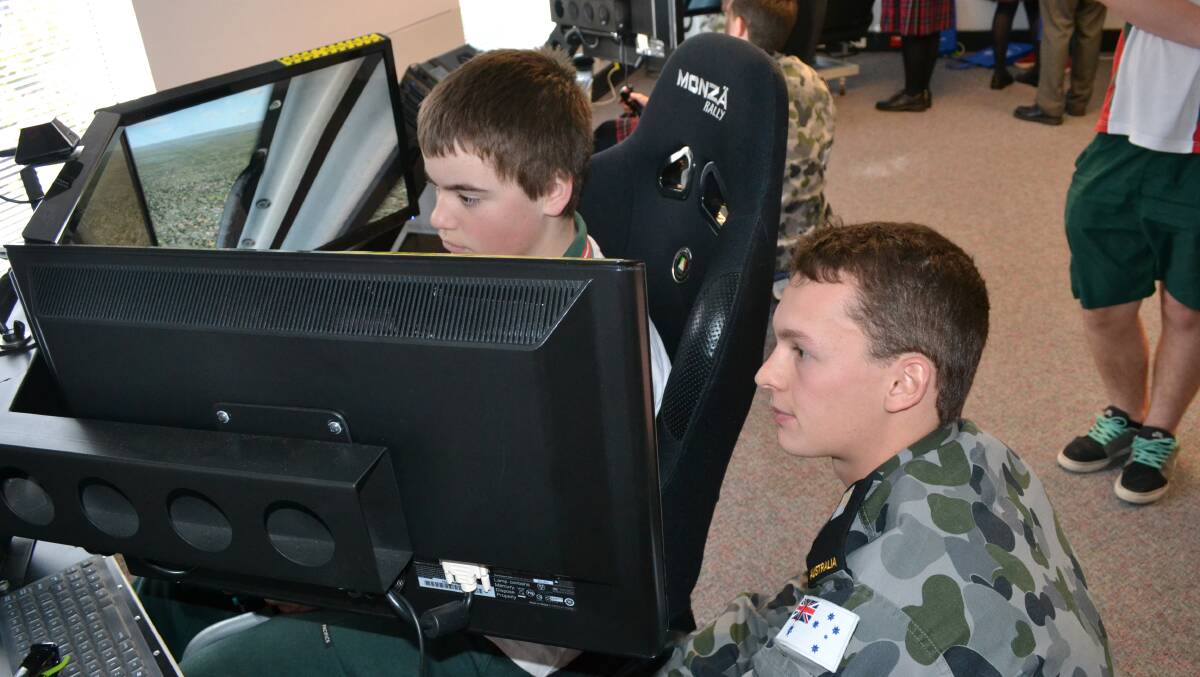 FLYING HIGH: David Falge from Bomaderry High School tests out a simulator with Midshipmen Joshua Gorrie from HMAS Albatross at the Shoalhaven Careers Expo.