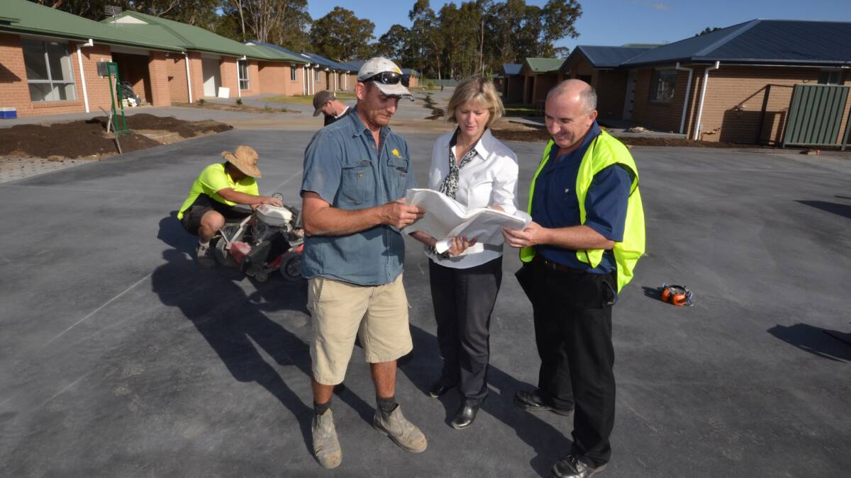 CLEVER DESIGN: Site foreman Luke Downes, Southern Cross Community Housing CEO Marg Kaszo and asset manager Gary Watkins take a closer look at the 19 community housing units on Yalwal Road. The development is nearing completion on time and on budget.