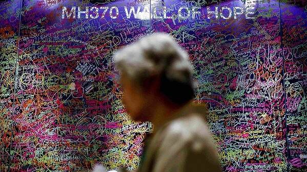 A woman walks past a message board in support of the passengers and family members of the missing Malaysia Airlines Flight MH370, at a shopping mall in Bangsar near Kuala Lumpur. Photo: REUTERS 