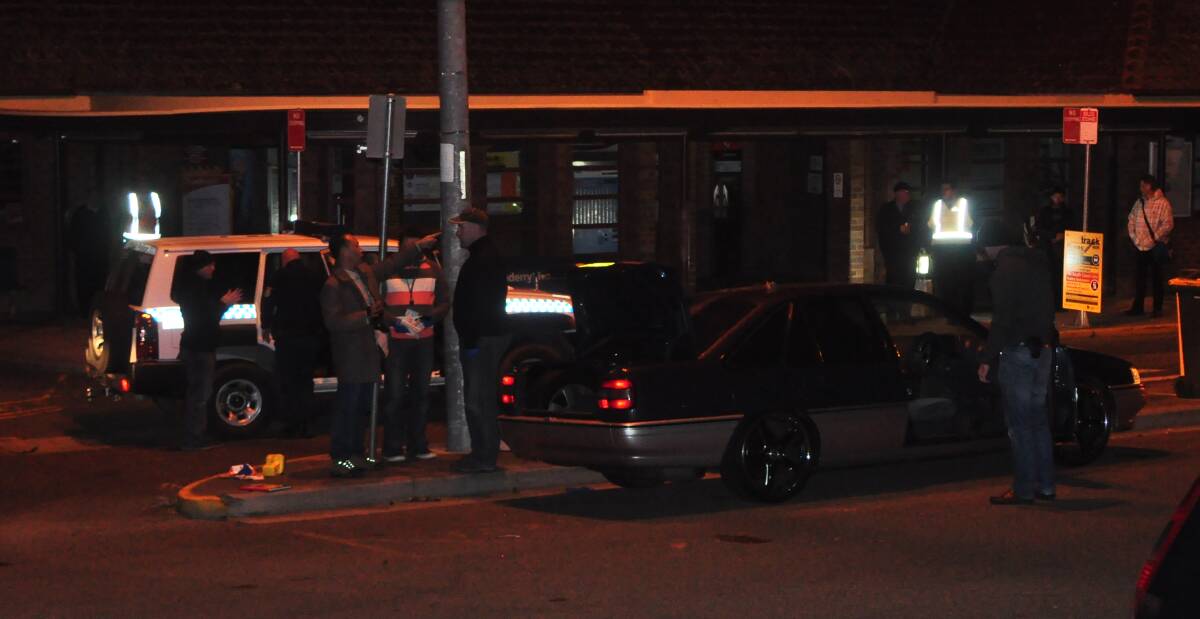 DRAMA: Officers from the State Crime Command gather evidence from a vehicle at Bomaderry railway station on Tuesday night.
