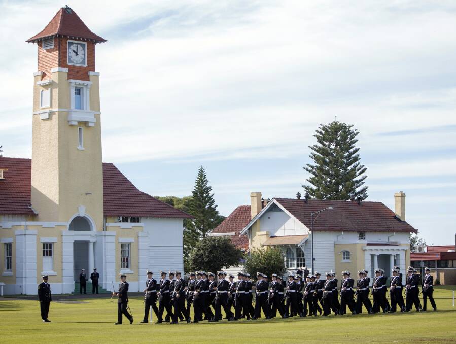 SPIT AND POLISH: New officers march past the iconic clock tower at HMAS Creswell during the new entry officers course (NEOC) 50 passing out parade on Thursday. 	Photo: YURI RAMSEY
