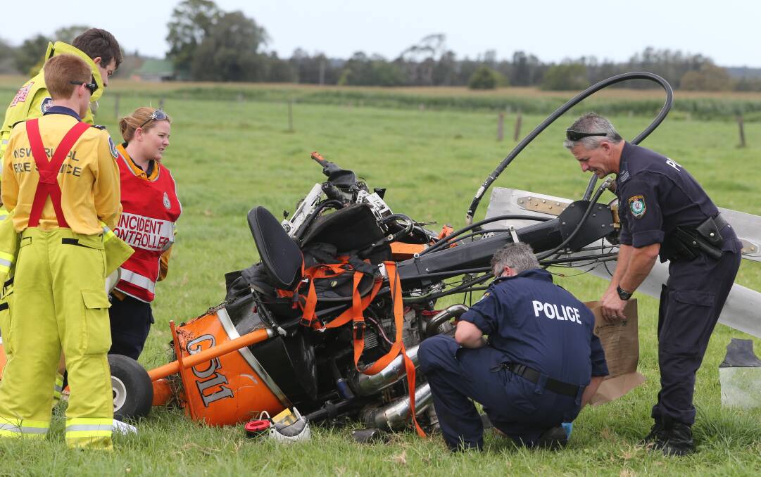 TRAGIC END: Police inspect the wreckage of a gyrocopter which crashed in a Brundee paddock, killing the pilot instantly.