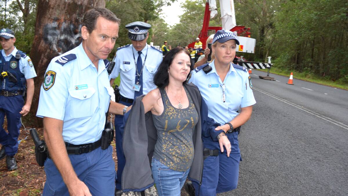 POINT MADE: Alison Darling from Gerroa is led away by police during the Bum Tree protest on Gerroa Road. 